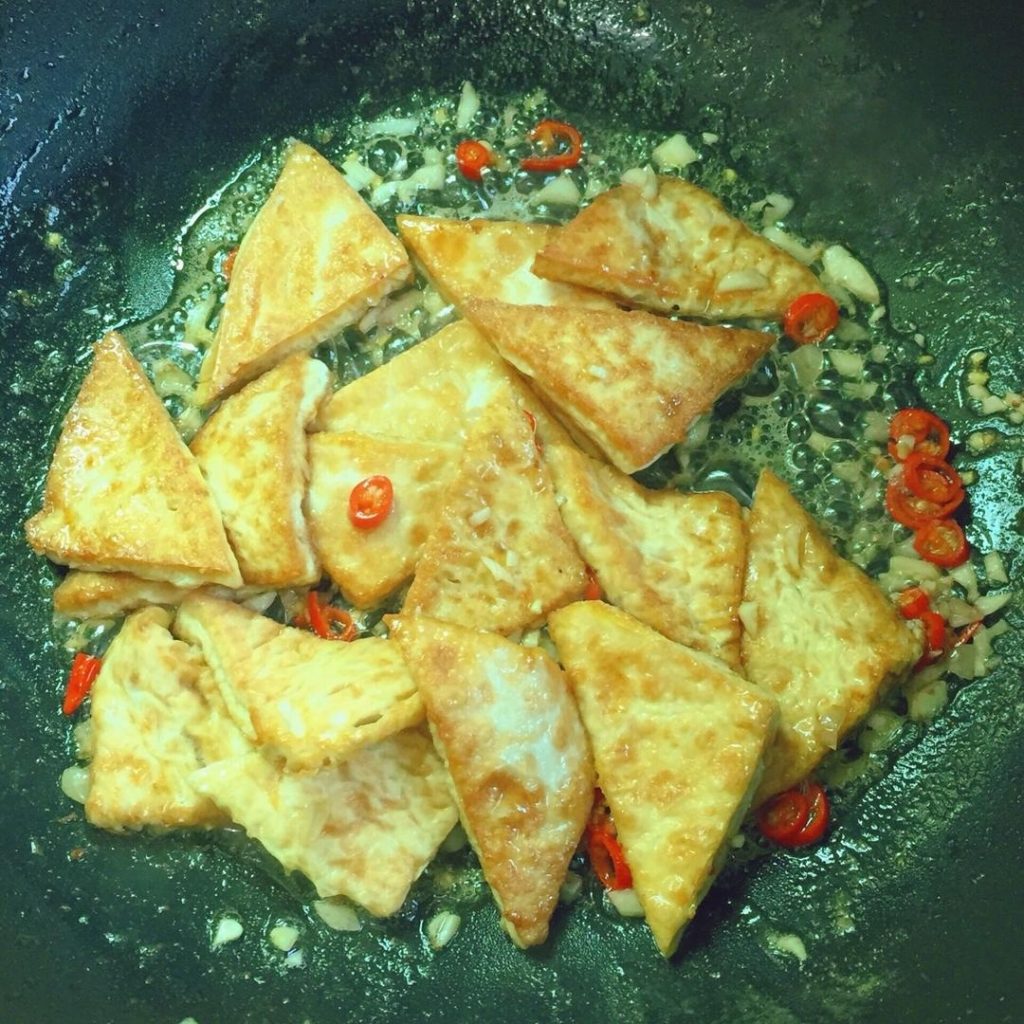 Gently return the fried tofu to the pan.