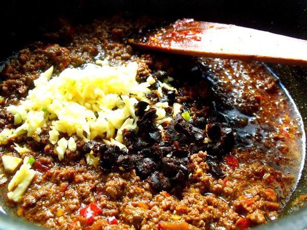 Aromatics Add the chili powder, minced garlic, and crushed fermented black beans (Douchi).