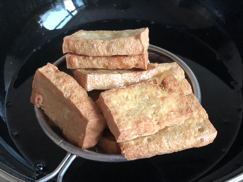 Remove the tofu with a slotted spoon and place it on a wire rack or paper towel to drain excess oil.