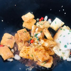 Braise the Tofu Return the fried tofu to the pan and toss gently to mix with the aromatics.