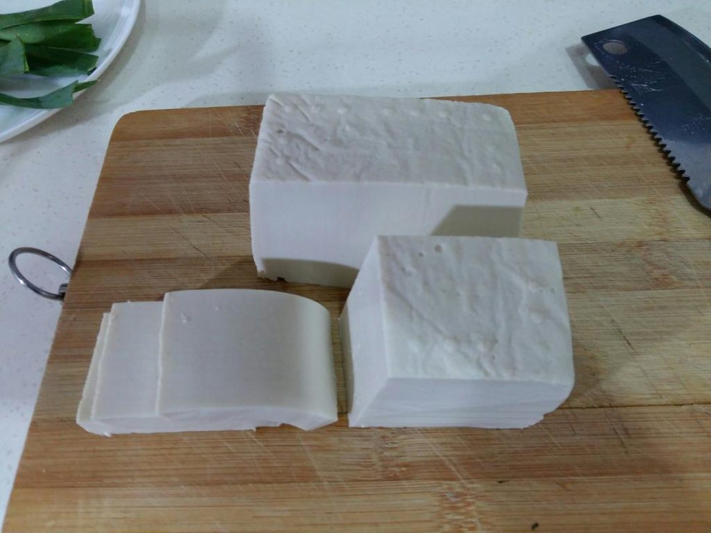 Prep the Tofu: Slice the block of tofu in half lengthwise, then cut it into thick rectangular slices (about 0.5 inches / 1.5 cm thick).
