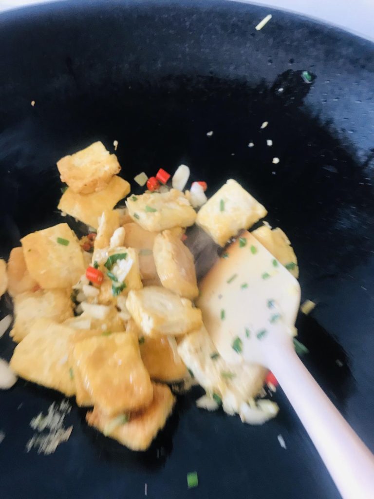 Braise the Tofu Return the fried tofu to the pan and toss gently to mix with the aromatics.
