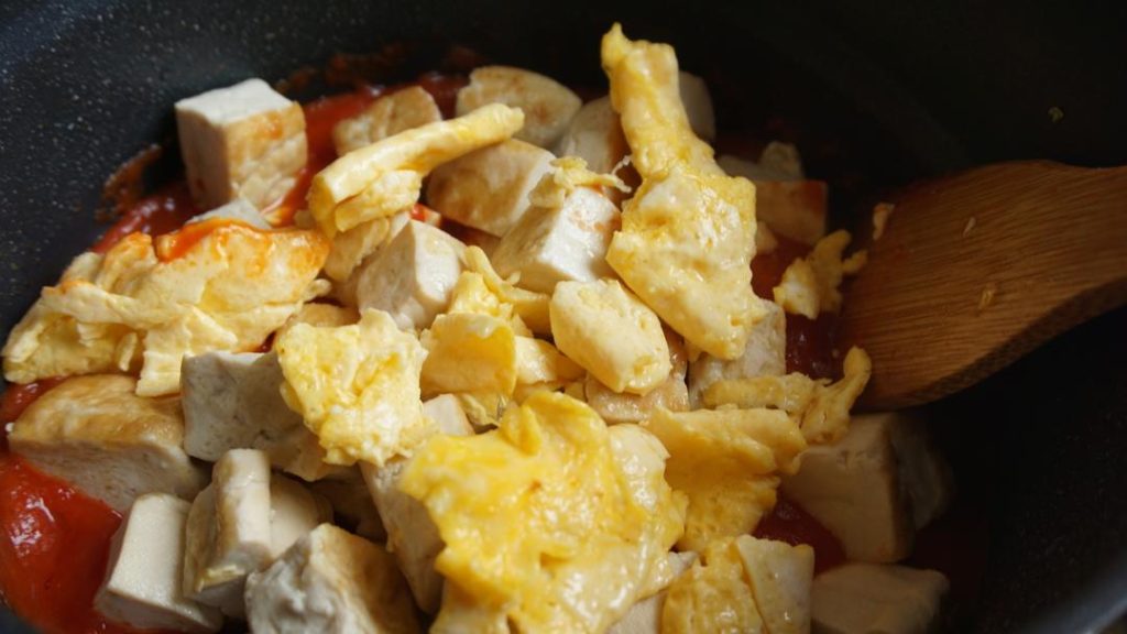 Braise Return the cooked eggs and tofu to the pan. Gently toss them in the tomato base to coat.