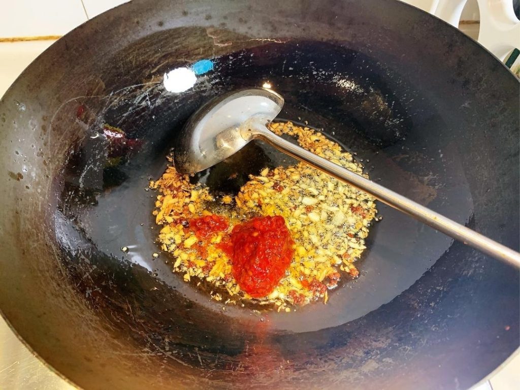 Create the Red Oil Add 2 tablespoons of Doubanjiang to the oil.