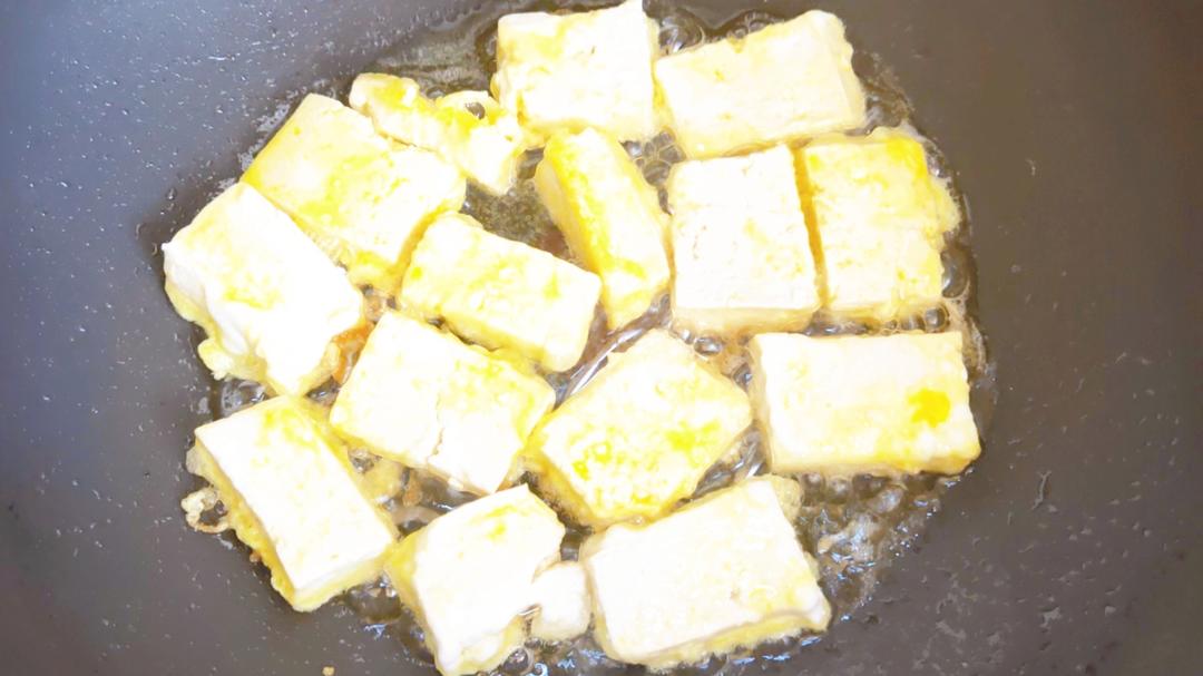 Fry the coated tofu over low heat in a single layer.