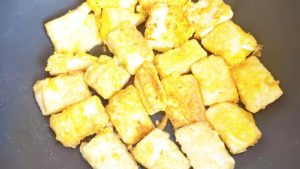 Fry until both sides of the tofu are golden and crisp.