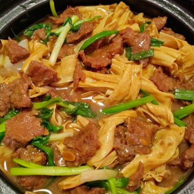 Velveted beef over yuba in a clay pot under a bean-paste sauce