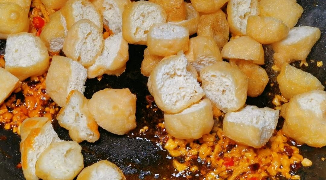 Add the halved tofu puffs and stir-fry until