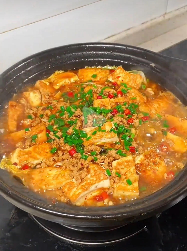 Golden tofu stacked in a clay pot under savory pork mince