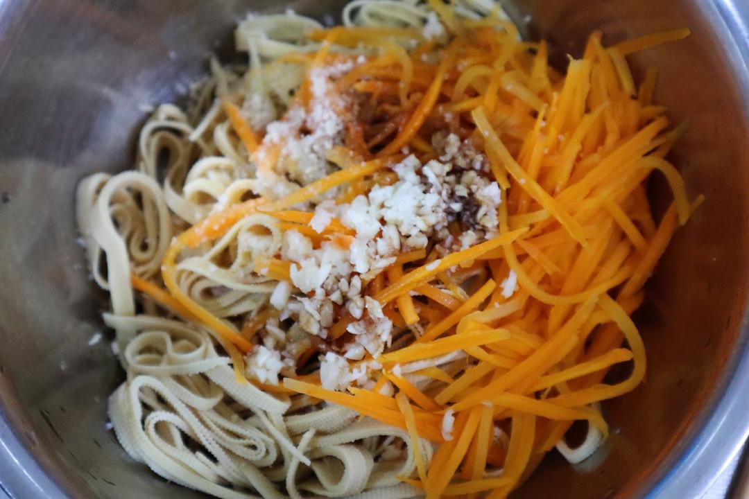 Shred the tofu skin; add the carrot, garlic,