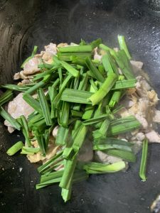 Return the pork and add the garlic-scape gree