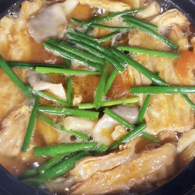 Golden egg-coated yuba simmered with tomato in a clay pot