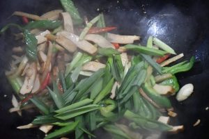 Add the garlic-scape greens, toss a while, an