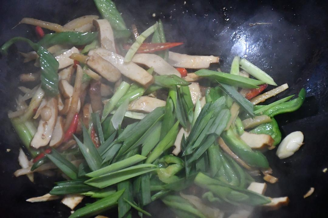 Add the garlic-scape greens, toss a while, an