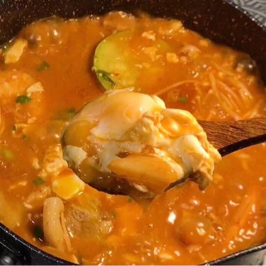 Red Korean stew with a whole box of silken tofu and an egg
