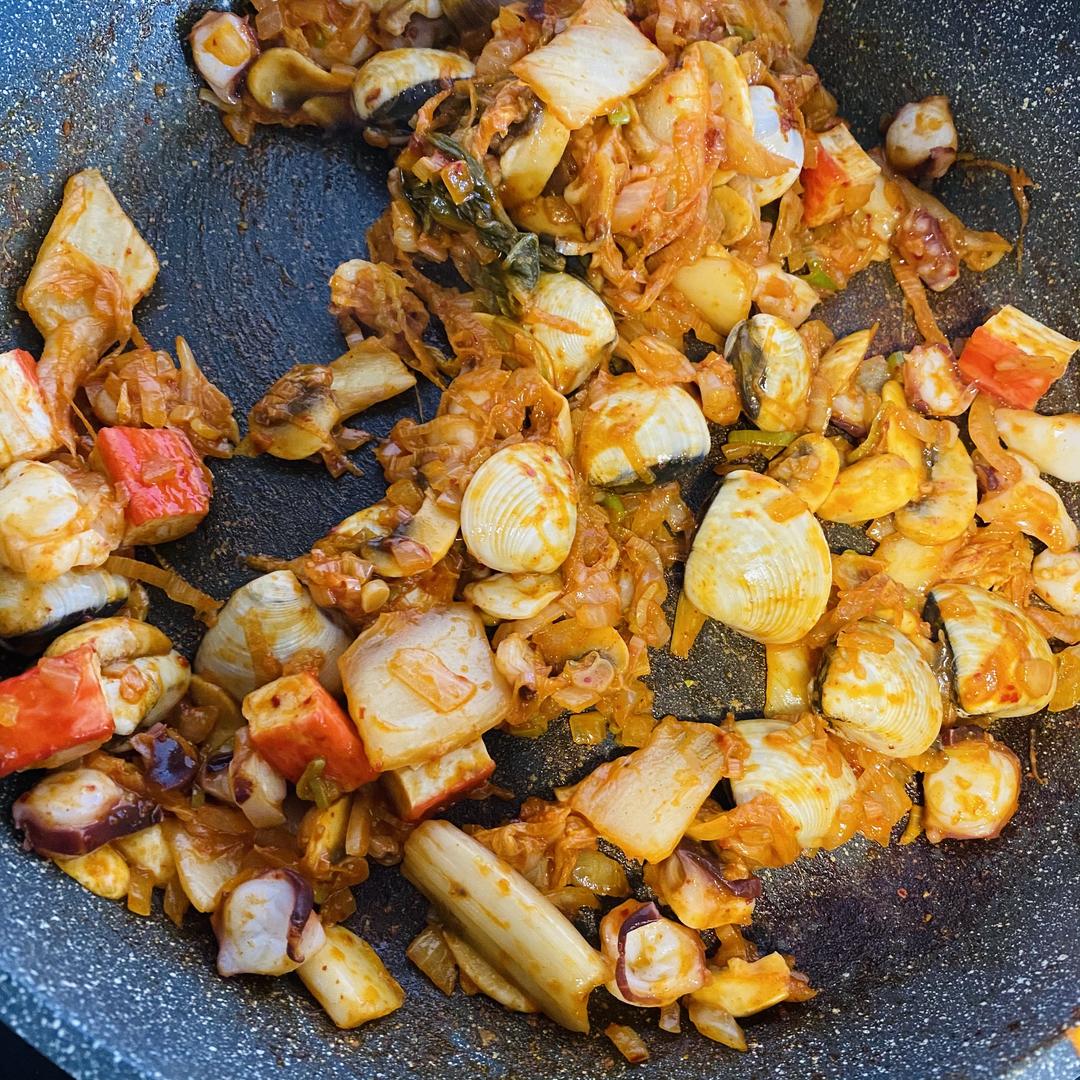 Add the seafood and the kimchi with a spoon o