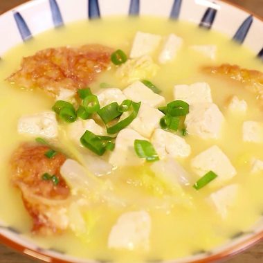 Milky white broth with golden egg, tofu, and napa cabbage