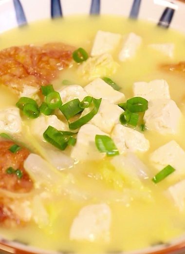 Milky white broth with golden egg, tofu, and napa cabbage