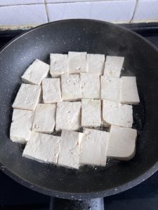 Heat oil in the pan and lay the tofu in one l