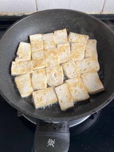 When both sides are golden, lift the tofu out