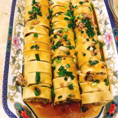 Sliced tofu-skin pork rolls glazed on a plate
