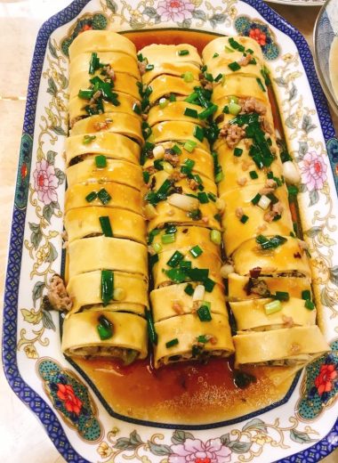 Sliced tofu-skin pork rolls glazed on a plate