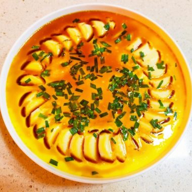 Rounds of egg tofu in a steamed milk custard with scallion